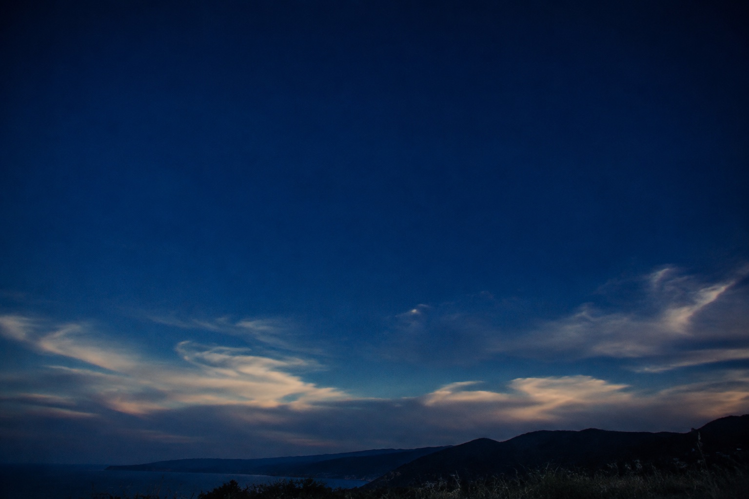 An expansive blue evening sky above a quiet horizon
